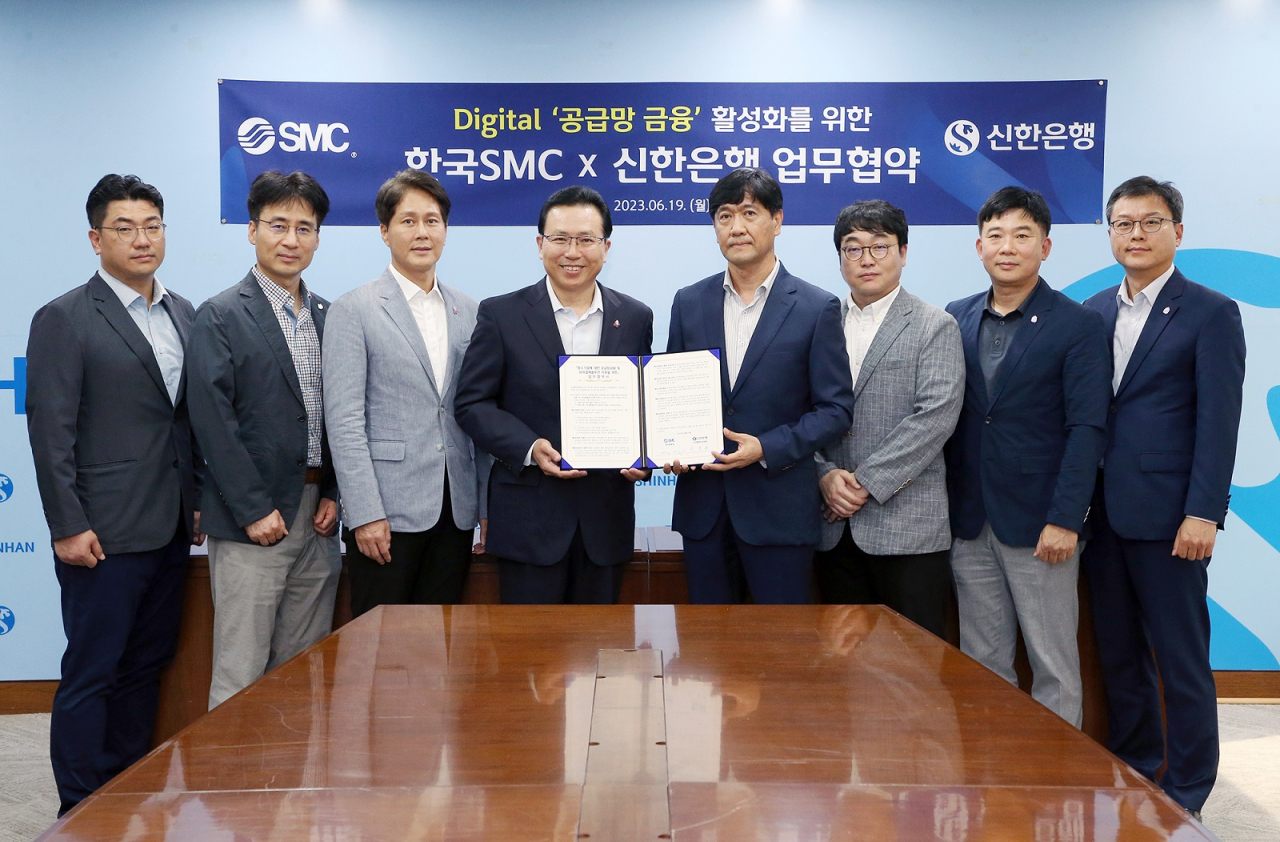 19일 서울시 중구 소재 신한은행 본점에서 전필환(왼쪽에서 네번째)신한은행 디지털혁신부문장과 홍성진(다섯번째) 한국SMC 관리본부장 및 양사 직원들이 디지털 ‘공급망 금융’ 활성화를 위한 업무협약식에서 기념촬영을 하고 있다.[신한은행 제공]