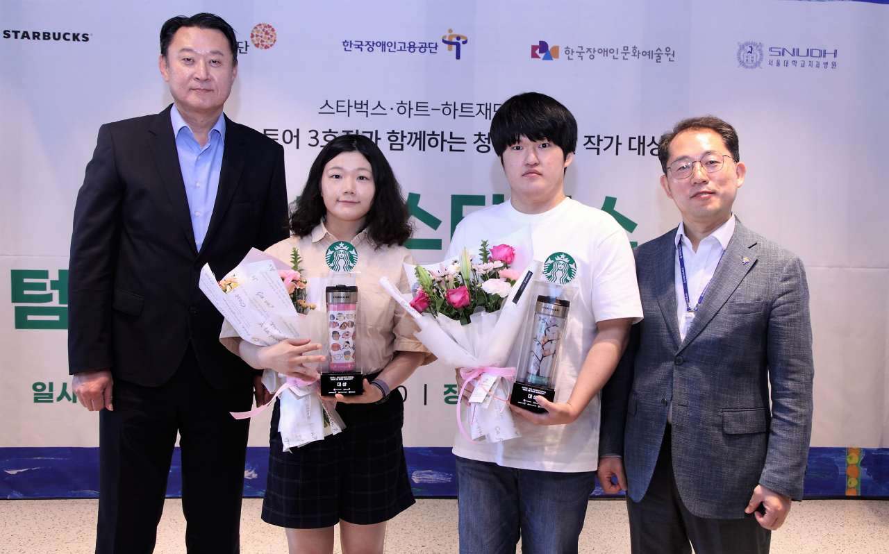 스타벅스 제3회 텀블러 그림 공모전 대상 수상자들이 기념촬영을 하고 있다. 왼쪽부터 손정현 스타벅스 코리아 대표, 대상 수상자 박예슬·하영윤 씨, 차정훈 한국장애인고용공단 고용촉진이사. [스타벅스 코리아 제공]