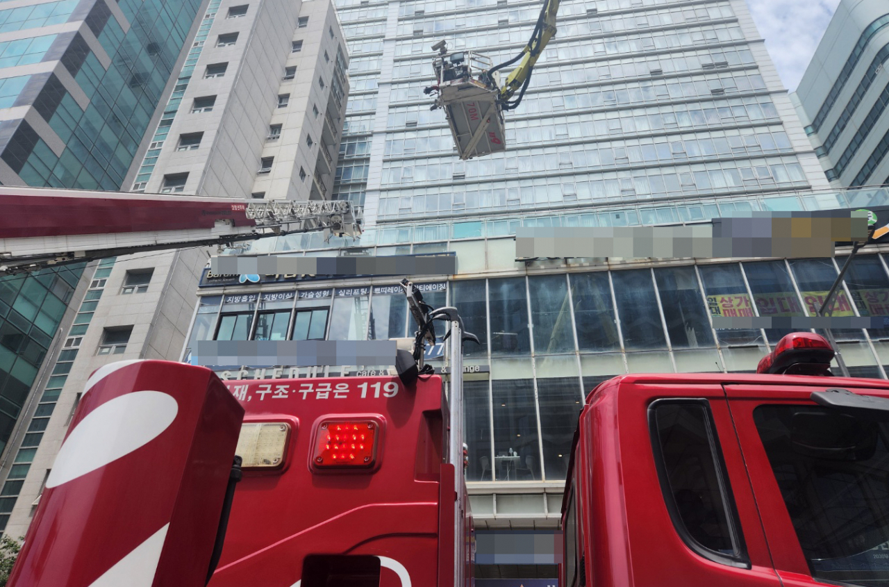 20일 오전 9시34분께 부산 해운대구 한 호텔 건물 지하에서 불이 나 소방 당국이 고가사다리차를 투입해 투숙객을 밖으로 대피시키고 있다. [연합뉴스]