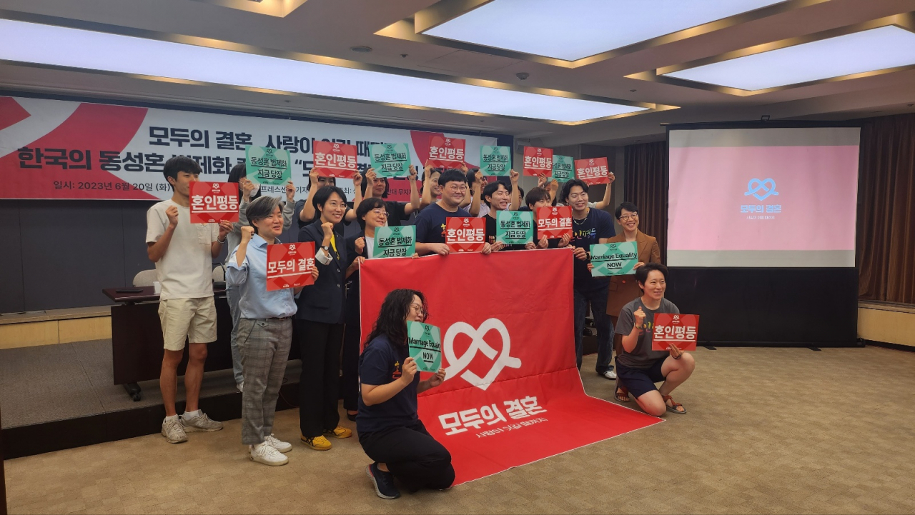 Activists holding signs reading "Marriage equality" pose for a picture behind a "Marriage Equality Korea" banner following a press conference held at Jung-gu, Seoul, on Tuesday.