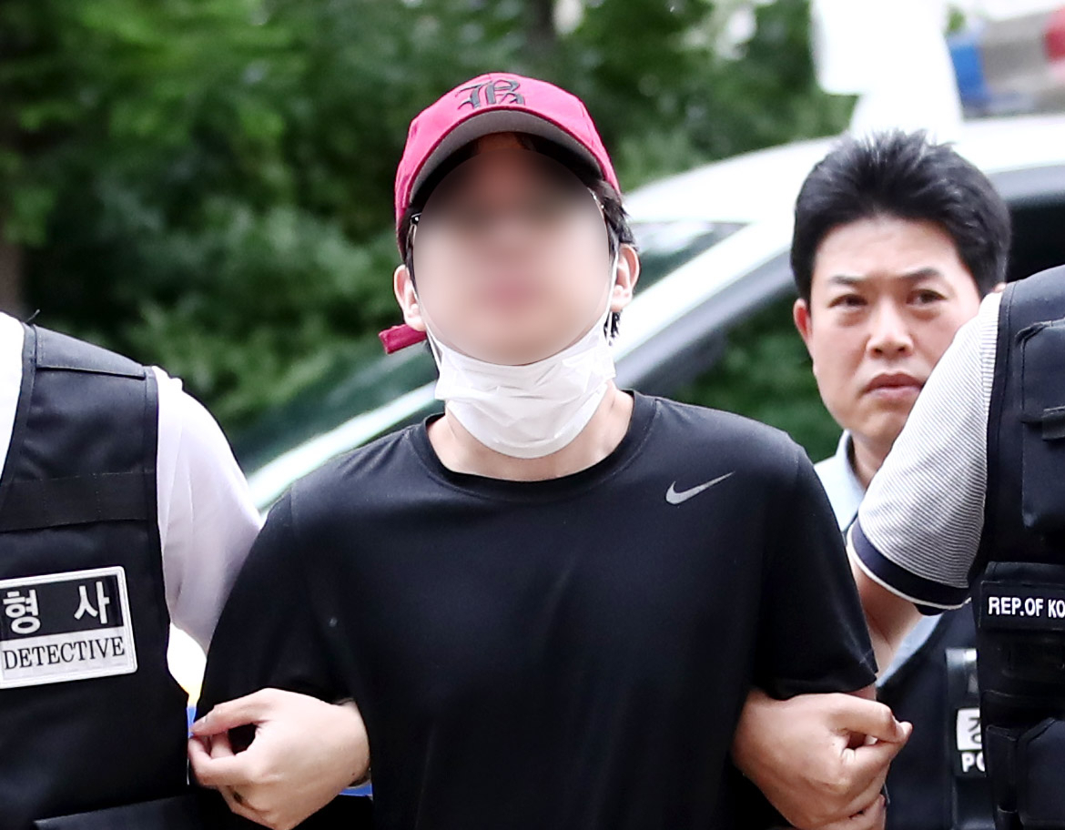 인천국제공항으로 향하던 여객기에서 비상문을 열려고 한 혐의를 받는 10대 남성이 20일 오후 구속 전 피의자 심문(영장실질심사)을 받기 위해 인천지법으로 들어서고 있다. 이 남성은 취재진을 향해 걸어오던 중 마스크를 턱 밑으로 내리며 얼굴을 공개했다. [연합]