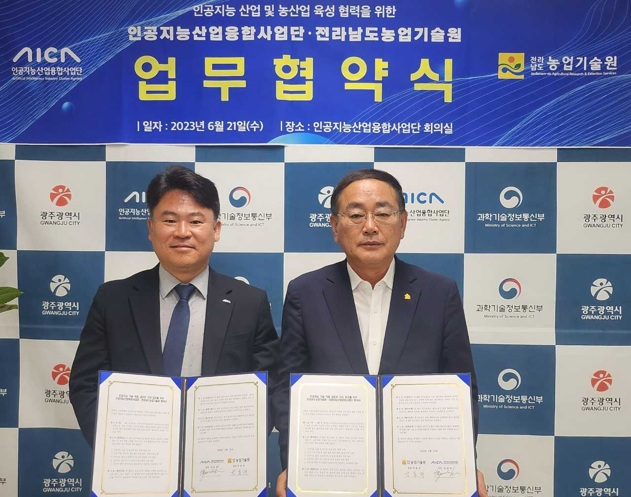 김준하 인공지능산업융합사업단장(왼쪽 사진)이 21일 광주 AI사업단 회의실에서 박홍재 전남농업기술원장과 ‘스마트농업 확산 및 농업 기술 혁신을 위한 업무협약’을 체결하고 있다.