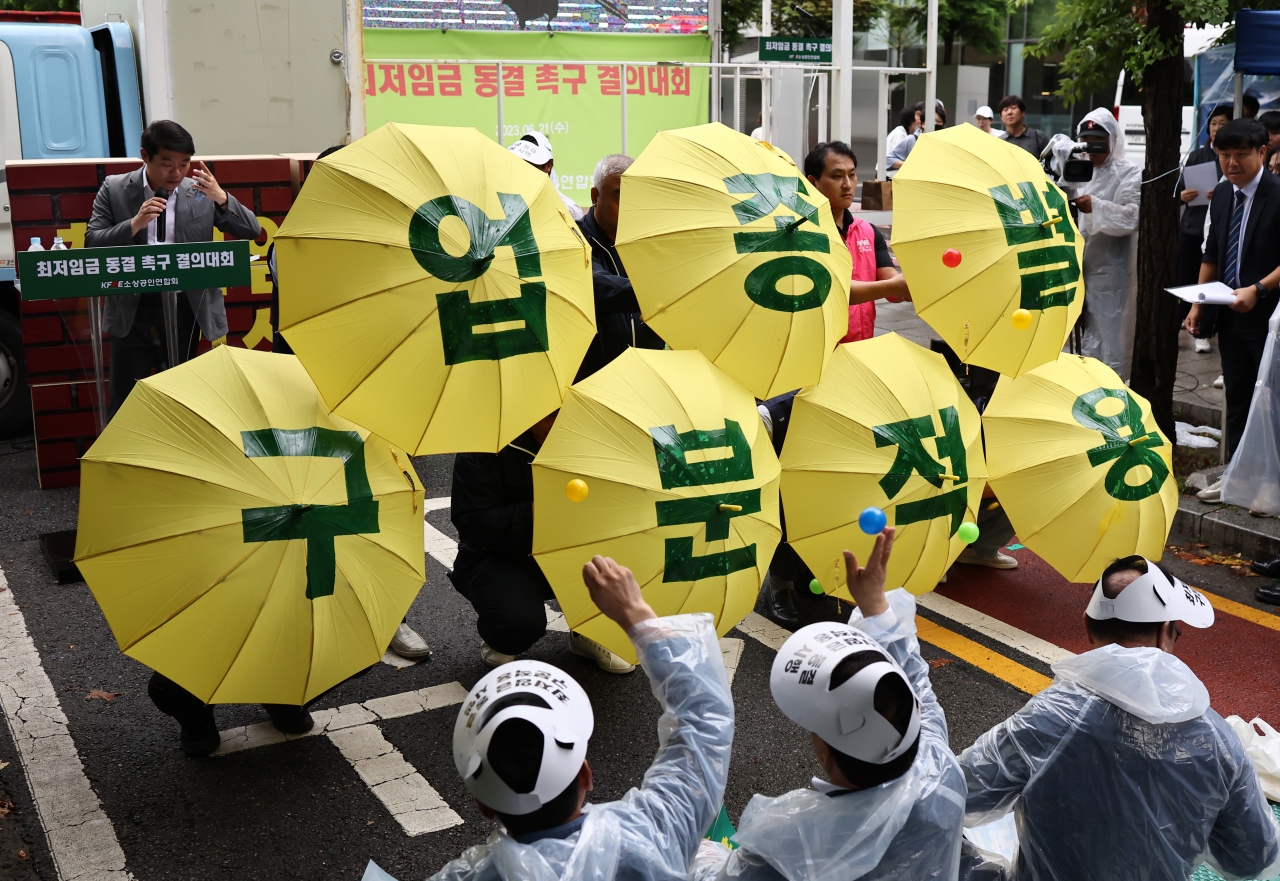 21일 오후 서울 국회의사당역 인근에서 열린 최저임금 동결 촉구 결의대회에서 소상공인연합회원들이 관련 퍼포먼스를 하고 있다. [연합]