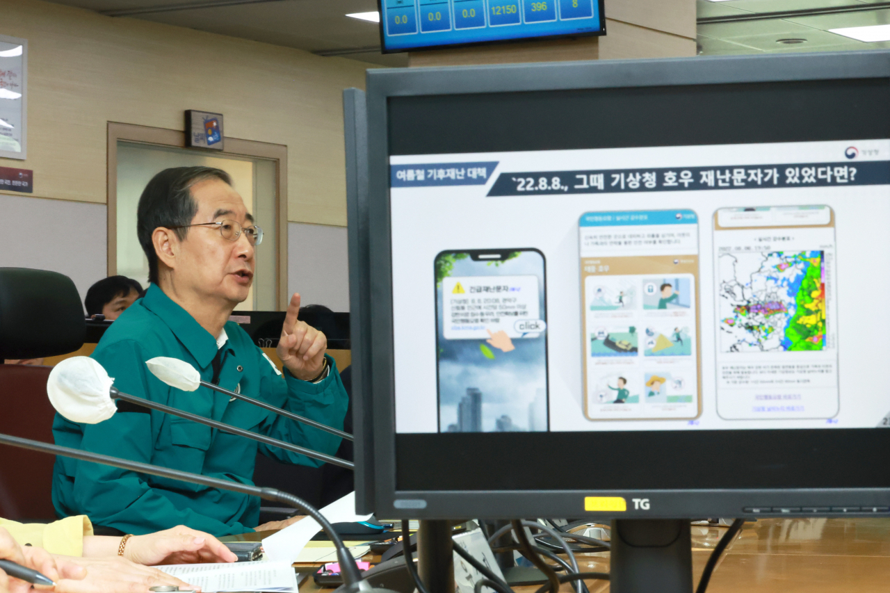 한덕수 국무총리가 23일 서울 동작구 기상청 국가기상센터 상황실에서 집중호우 재난문자시스템 시연을 살피고 있다. [연합]