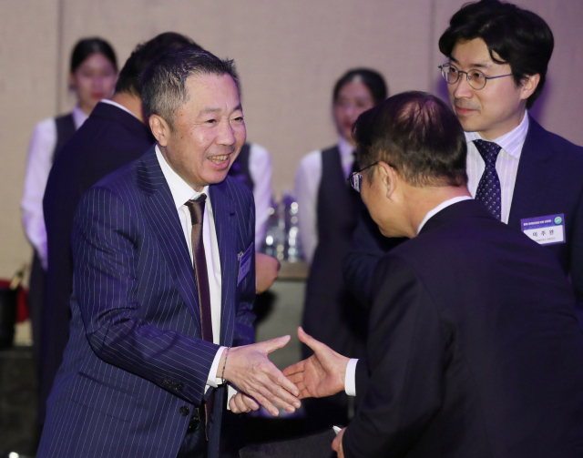 22일(현지시간) 베트남 하노이 한 호텔에서 열린 윤석열 대통령과 동행 경제인 만찬 간담회에서 박정원(왼쪽) 두산그룹 회장이 이정식 고용노동부 장관과 악수하고 있다 [연합]