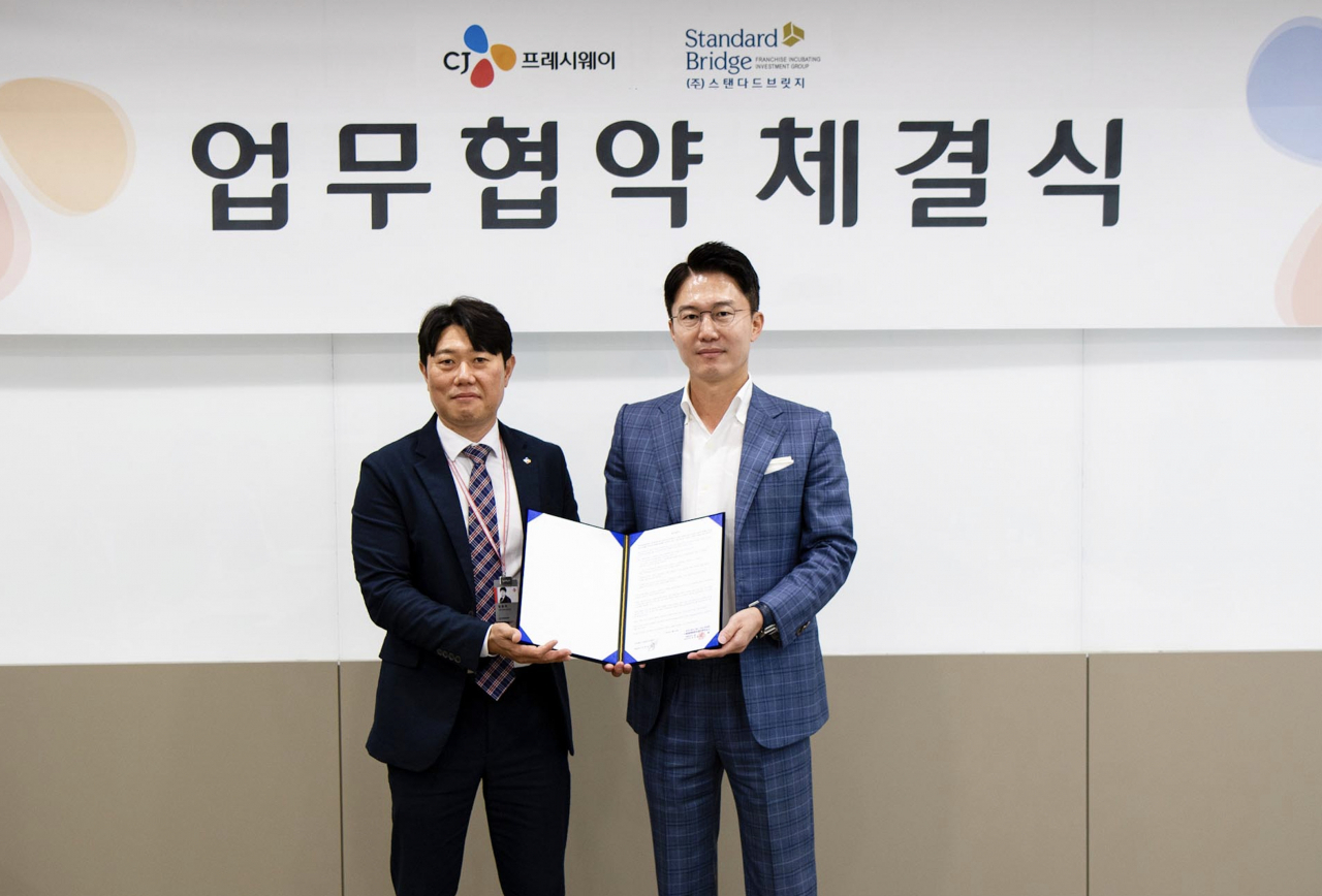 22일 서울 마포구 상암동 CJ프레시웨이 본사에서 임종욱(왼쪽) CJ프레시웨이 외식SU 사업부장과 이영복 스탠다드브릿지 대표이사가 업무협약 체결 후 기념촬영을 하고 있다. [CJ프레시웨이 제공]