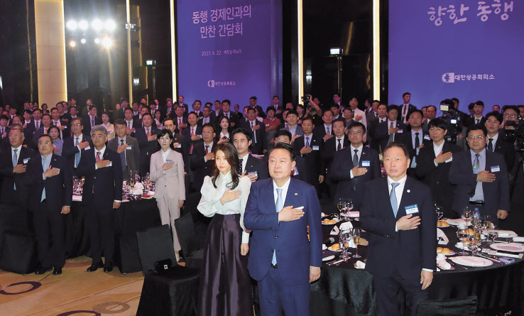 22일(현지시간) 하노이 한 호텔에서 열린 베트남 동행 경제인 만찬 간담회에서 윤석열 대통령과 김건희 여사, 최태원(앞줄 오른쪽 첫번째) 대한상공회의소 회장(SK그룹 회장), 정의선(뒷줄 왼쪽 첫번째) 현대차그룹 회장, 구자열(뒷줄 왼쪽 두번째) 한국무역협회장, 정원주(뒷줄 왼쪽 세번째) 대우건설 회장 등이 국민의례를 하고 있다. [연합]