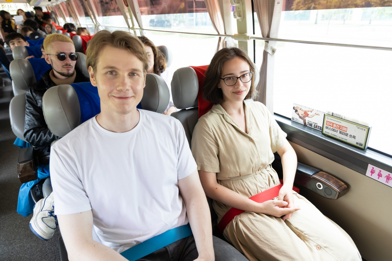 People sit on a bus with safety belts inspired by traditional Korean wrestling bands during a bus ride from Incheon Airport to central Seoul on June 20. The Ministry of Culture, Sports and Tourism announced that the "K-Wrestling safety belt" will be used on a designated airport bus route from May 31 to June 28. (Yonhap)