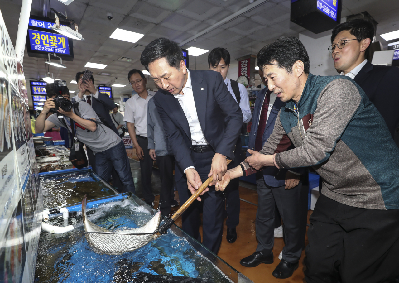 김기현 국민의힘 대표가 15일 오후 서울 동작구 노량진수산시장을 방문해 뜰채로 광어를 들고 있다. [연합]