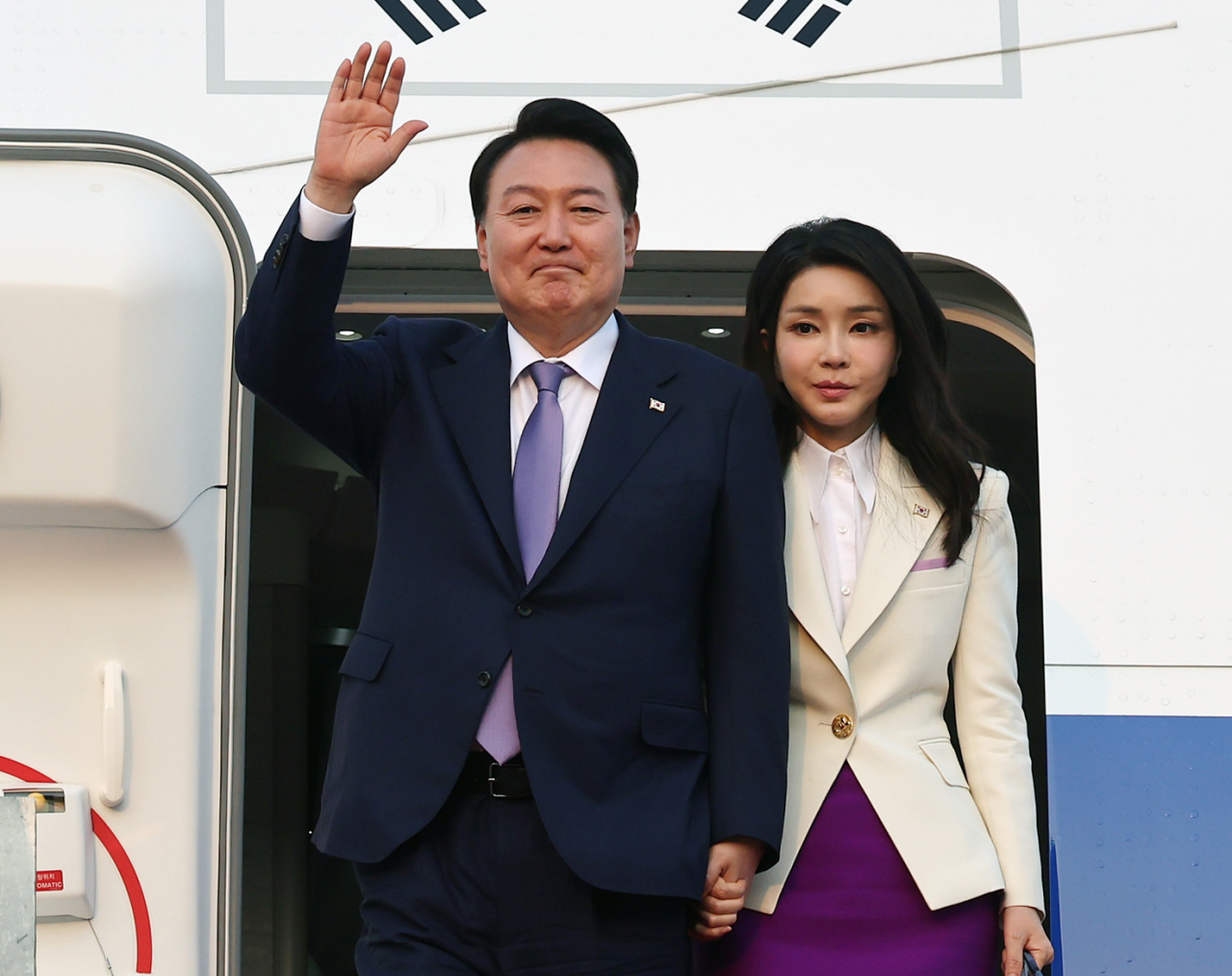프랑스·베트남 방문을 마친 윤석열 대통령과 김건희 여사가 24일 오후 성남 서울공항에 도착해 공군 1호기에서 내리며 손을 들어 인사하고 있다. [연합]