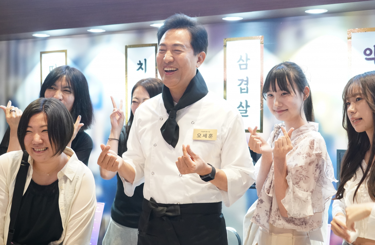 오세훈 서울시장이 24일 도쿄 메트로폴리탄 인더스트리얼 센터에서 열린 ‘서울관광 프로모션 행사’에서 쉐프복을 입고 현장에 방문한 일본인들과 ‘손가락 하트’를 하고 있다. [서울시 제공]
