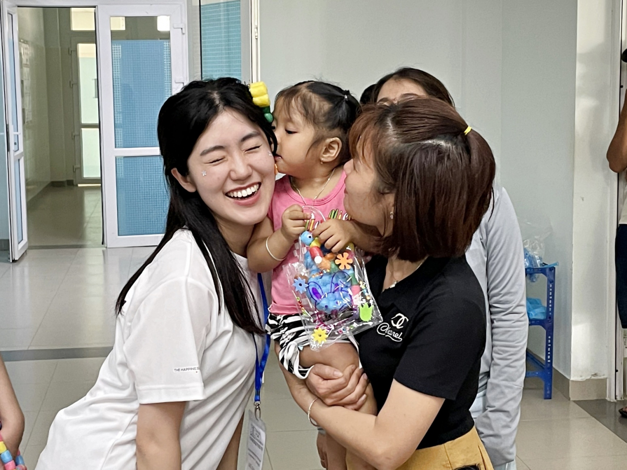 ‘베트남 얼굴기형 어린이 무료수술’ 행사에 참여한 SK 대학생 자원봉사단 ‘SK 써니’ 참가자가 수술한 어린이와 가족을 위로하는 봉사활동을 펼치고 있다. [SK 제공]