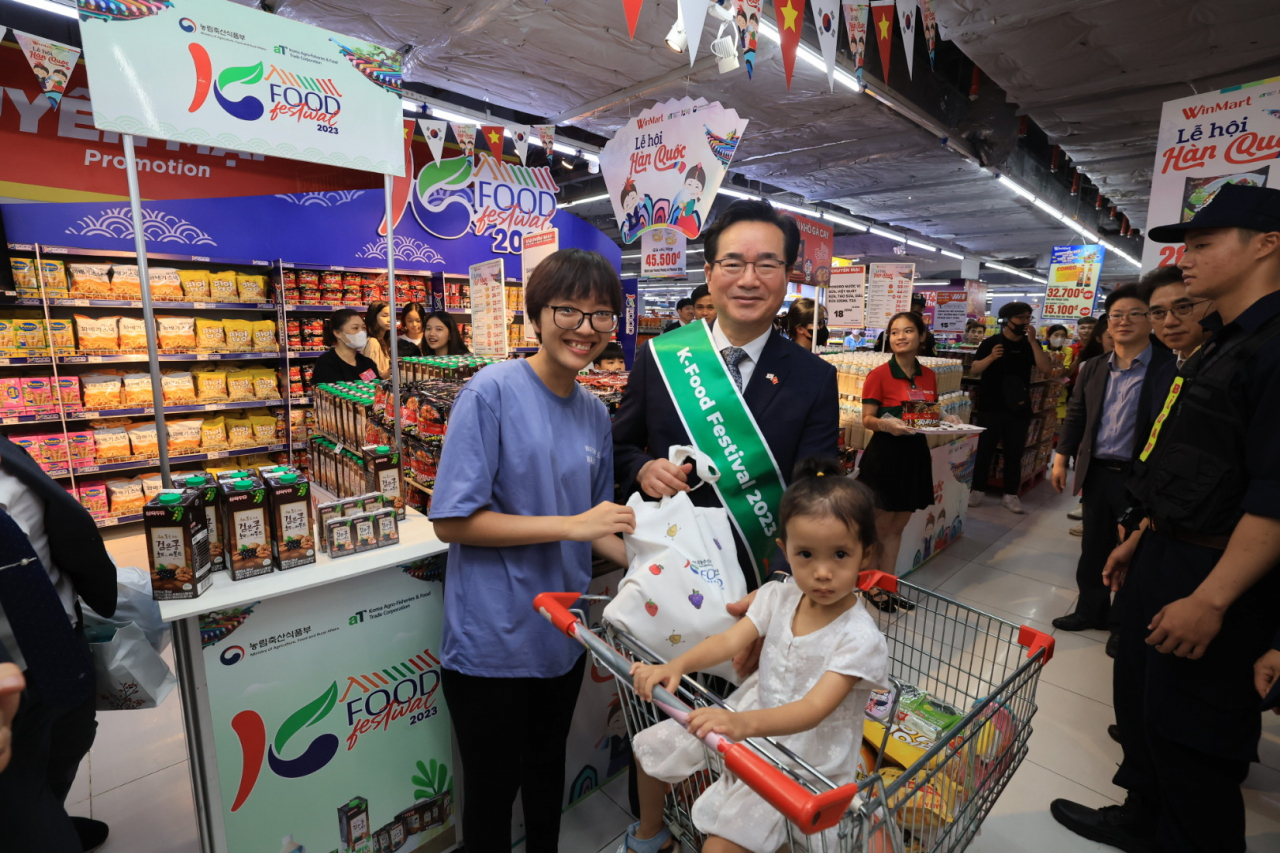 정황근 농림축산식품부 장관이 지난 24일 베트남 하노이 윈마트(Winmart)에서 K-푸드 판매 촉진 행사를 벌이던 도중 현지 소비자와 만나 사진 촬영을 하고 있다. [농림축산식품부 제공]