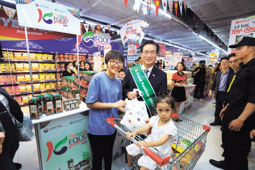 정황근 농림축산식품부 장관이 지난 24일 베트남 하노이 윈마트(Winmart)에서 K-푸드 판매 촉진 행사를 벌이던 도중 현지 소비자와 만나 사진 촬영을 하고 있다. [농림축산식품부 제공]