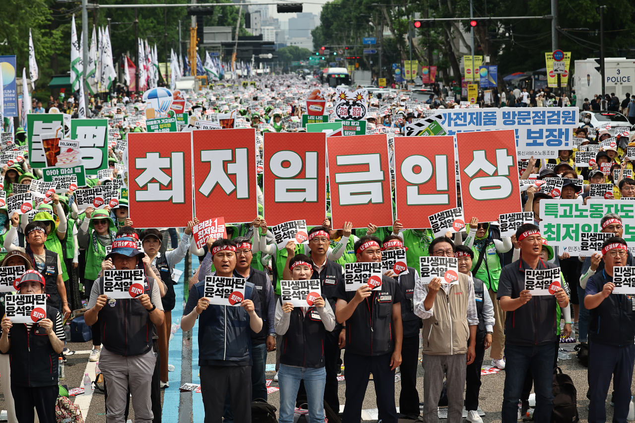24일 서울 혜화역 인근에서 열린 ‘윤석열 정권 퇴진 전국노동자대회’에서 민주노총 회원들이 최저임금 인상 등을 촉구하는 손 피켓을 들어 보이고 있다. [연합]