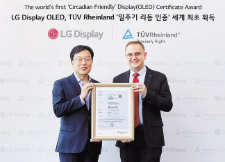 티유브이 라인란드 전자제품 인증 부문 글로벌 최고 책임자 프랭크 홀즈만이 윤수영(왼쪽) LG디스플레이 최고기술책임자(CTO) 부사장에게 인증서를 수여하고 있다. [LG디스플레이 제공]