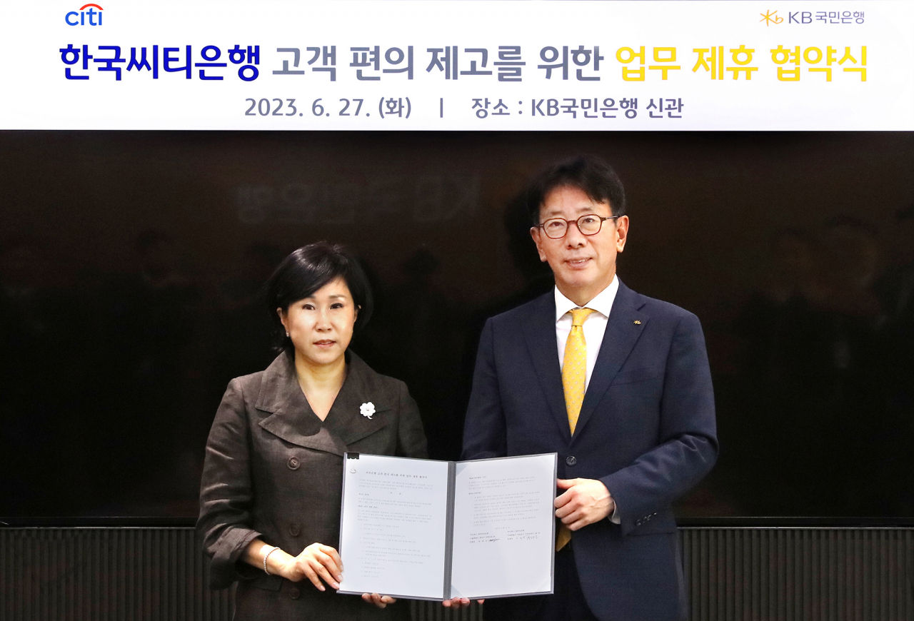 27일 서울 영등포구 KB국민은행 신관에서 열린 업무 제휴 협약식에서 이재근(오른쪽) KB국민은행장과 유명순 한국씨티은행장이 기념 촬영을 하고 있다.[KB국민은행 제공]