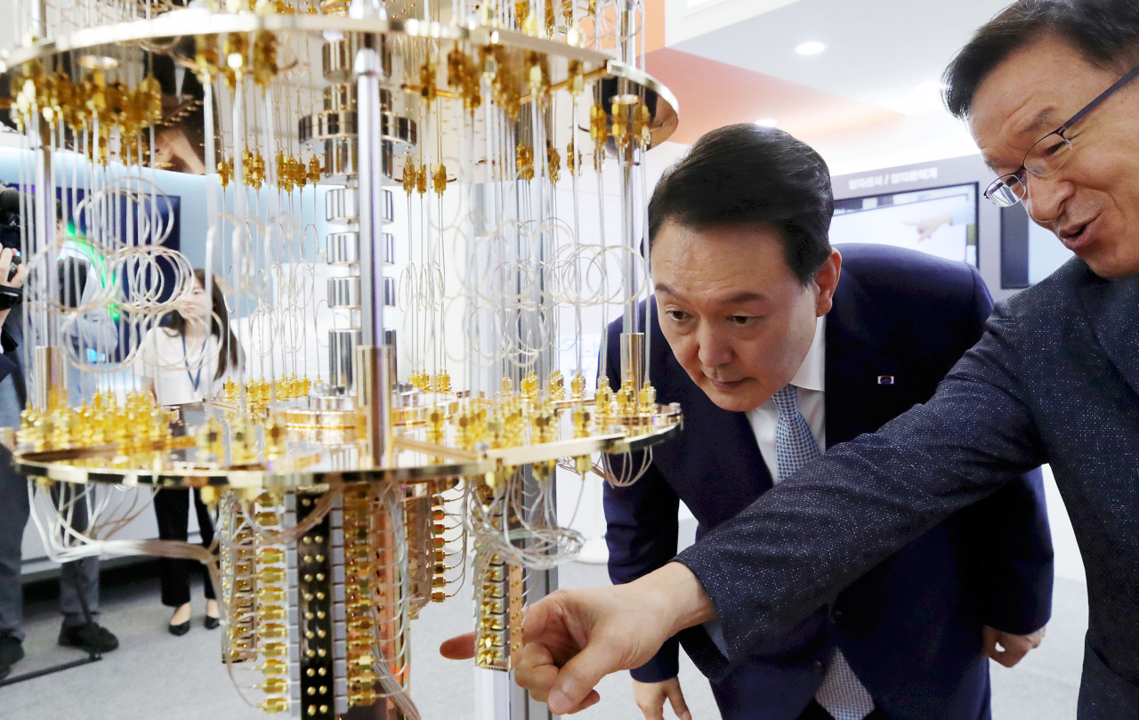 윤석열 대통령이 27일 서울 동대문디자인플라자(DDP)에서 열린 '양자과학기술 현재와 미래의 대화'를 마친 뒤 '퀀텀 코리아 2023' 전시관을 찾아 한국표준과학연구원의 초전도 기반 50큐비트 양자컴퓨터 모형에 관한 설명을 듣고 있다. [연합]