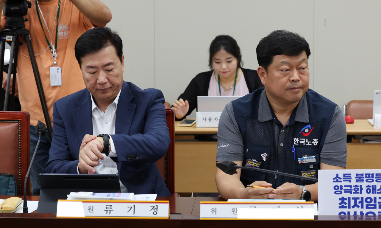 사용자위원인 류기정 한국경영자총협회 전무(왼쪽)가 27일 오후 세종시 정부세종청사 최저임금위원회 회의실에서 열린 제8차 전원회의에 참석해 시계를 보고 있다. 오른쪽은 근로자위원인 류기섭 한국노총 사무총장. 연합뉴스