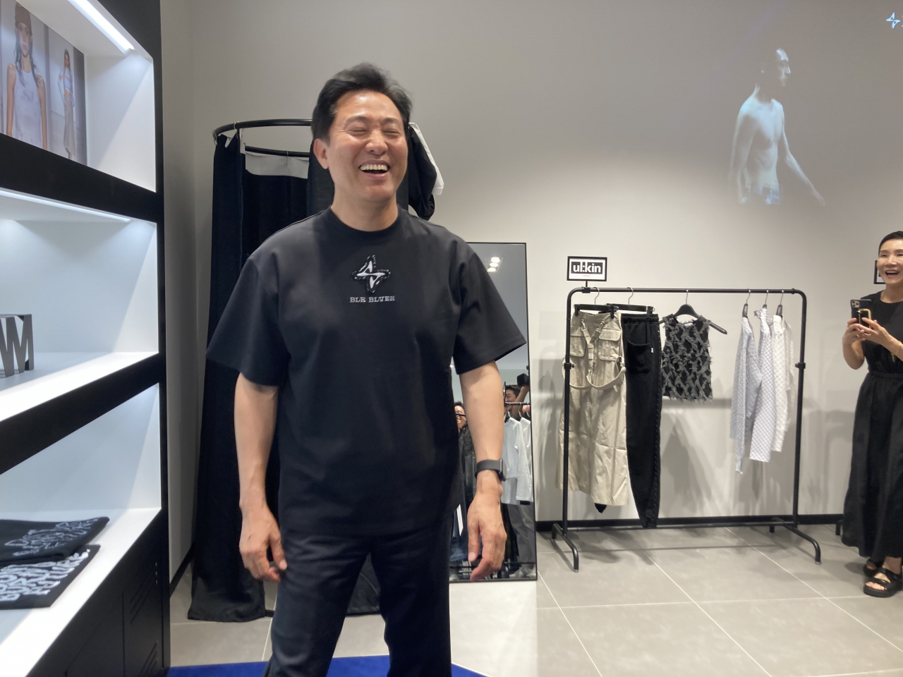 오세훈 서울시장이 27일 도쿄 긴자 롯데면세점에 문을 연 서울패션위크 브랜드관에서 추천받은 옷을 구입해 입은채로 웃고 있다. [서울시 공동취재단]