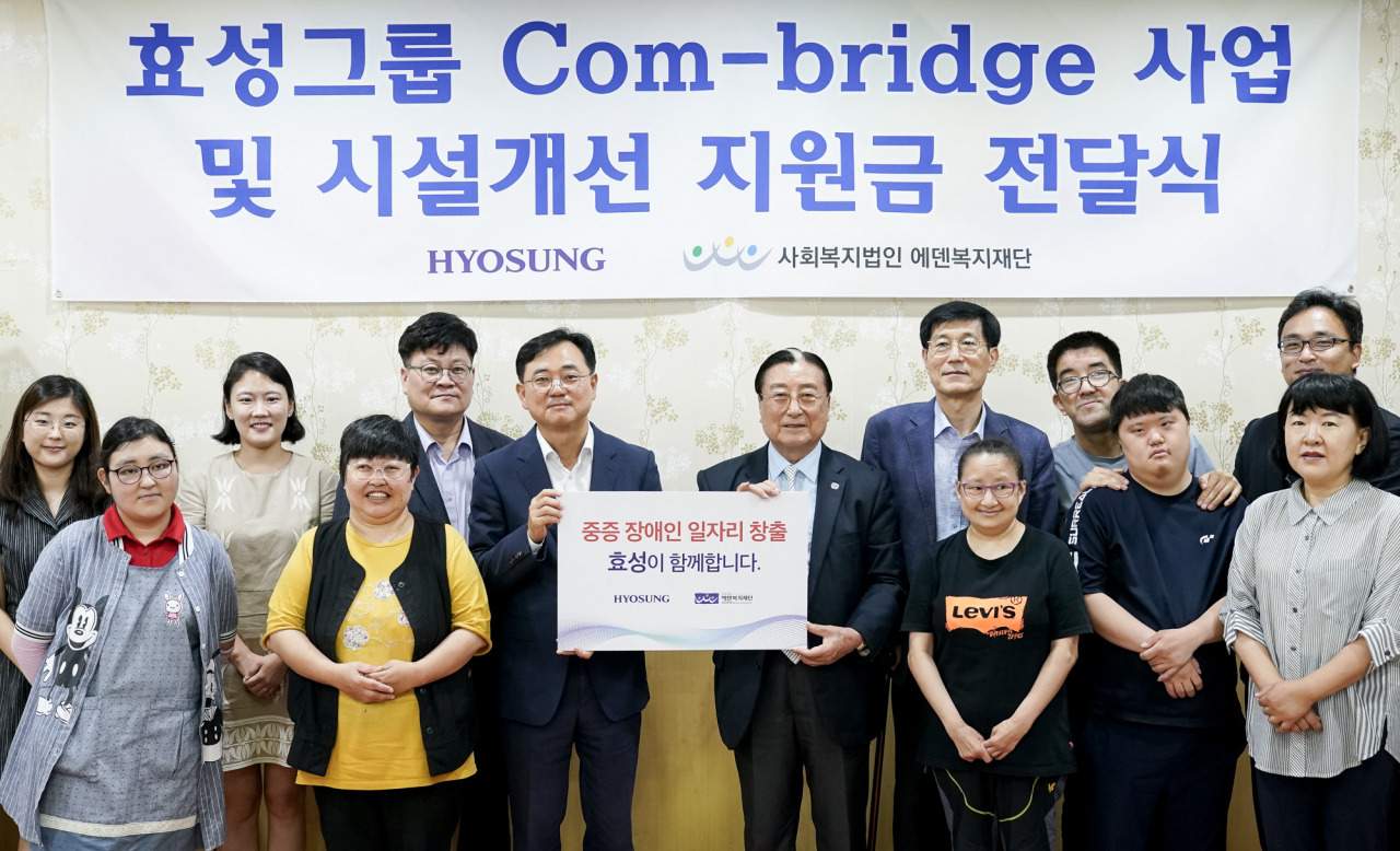 최형식(앞줄 왼쪽 세번째) 효성 커뮤니케이션실 상무가 29일 경기 파주시에 있는 중증장애인 일자리 창출 사회적기업 에덴복지재단에 시설 개선 지원금 2000만원을 전달한 뒤 김학수(앞줄 왼쪽 네번째) 에덴복지재단 이사장 등 관계자들과 기념촬영을 하고 있다. [효성 제공]