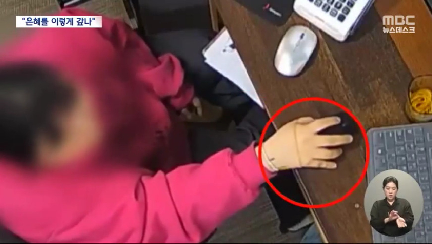 제주 한 공연장 매표소 직원 A씨가 현금을 묶기 위해 고무줄을 손에 걸고 있는 모습. 폐쇄회로(CC)TV에 찍힌 장면이다. [MBC 갈무리]
