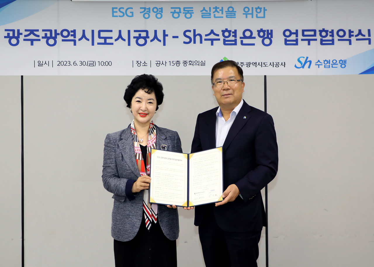 Sh수협은행은 6월 30일 광주도시공사와 ‘사회적 가치 실현을 위한 ESG경영 공동실천 업무협약’을 체결했다. 강신숙(왼쪽) 수협은행 은행장과 정민곤 광주도시공사 사장이 협약서에 서명하고 기념촬영을 하고 있다. [사진=수협은행]