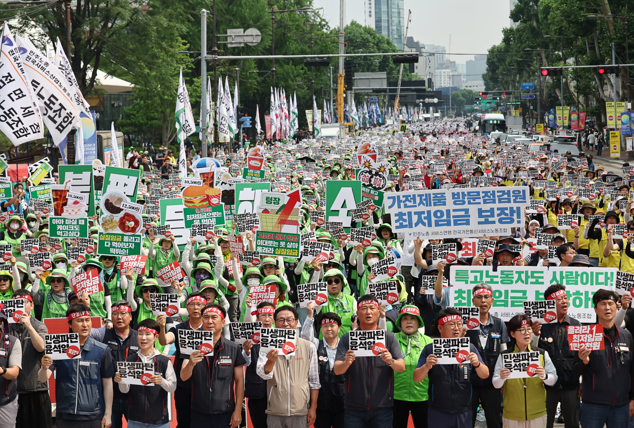 지난달 24일 서울 혜화역 인근에서 열린 ‘윤석열 정권 퇴진 전국노동자대회’에서 민주노총 회원들이 최저임금 인상 등을 촉구하는 손 피켓을 들어 보이고 있다. [연합]
