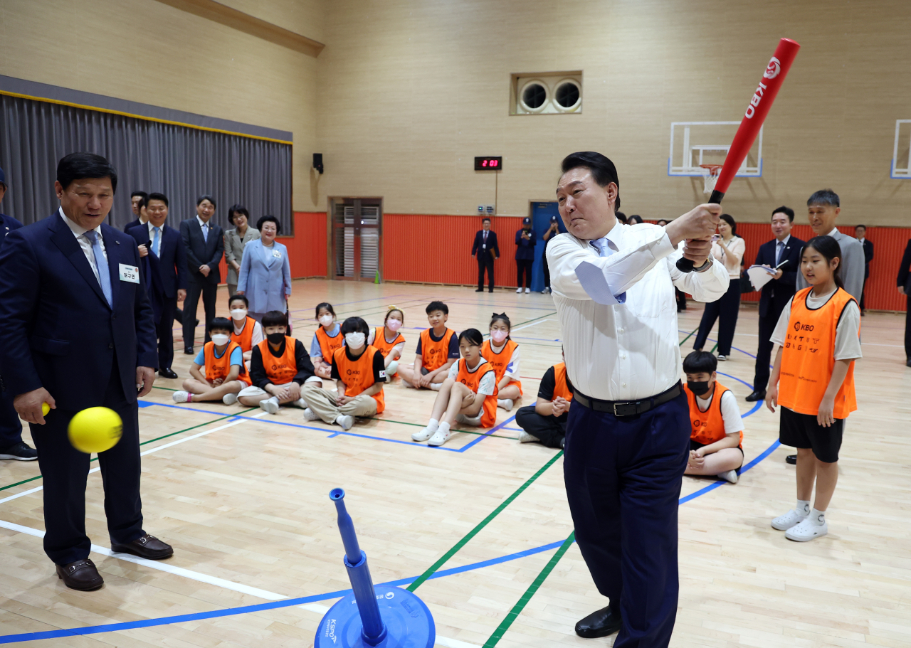 윤석열 대통령이 방과후 돌봄·교육 프로그램인 '늘봄학교' 참관을 위해 3일 경기도 수원초등학교를 방문, 전직 프로야구 선수들이 강사로 초등학생들을 지도하는 간이야구 프로그램을 지켜보던 중 티볼을 시타하고 있다. [연합]