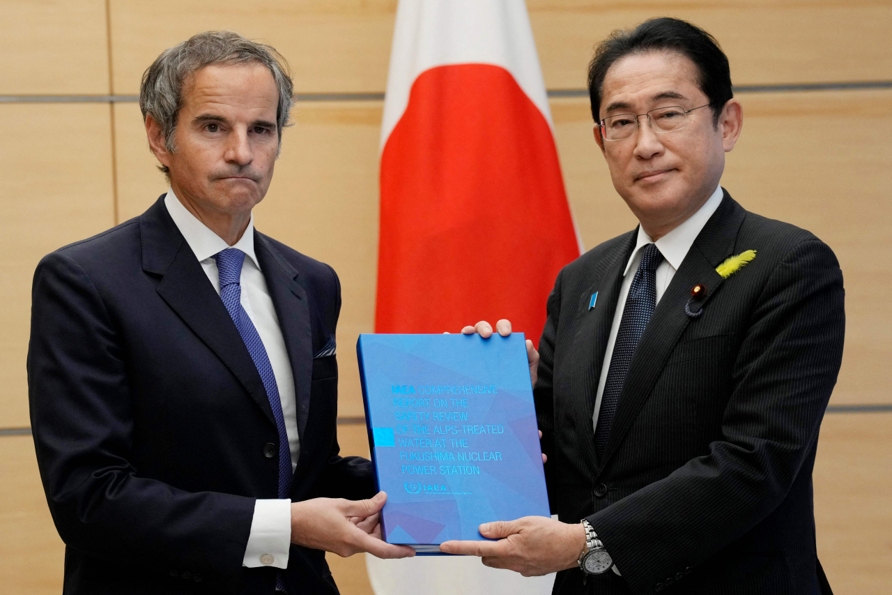 라파엘 그로시(왼쪽) 국제원자력기구(IAEA) 사무총장이 4일 도쿄 총리 관저에서 열린 회담에서 기시다 후미오 일본 총리에게 후쿠시마 처리수 방출에 관한 IAEA의 종합보고서를 발표하고 있다.[AFP]