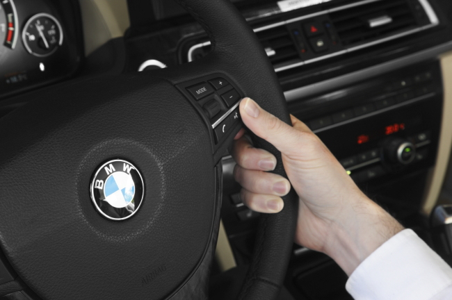 BMW 앰블럼이 장착된 스티어링휠을 운전자가 잡고 있는 모습. [BMW 제공]