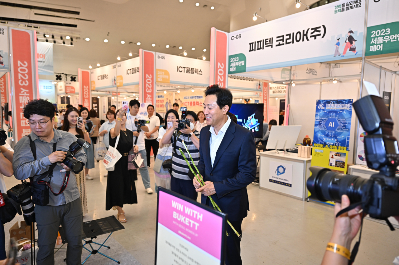 오세훈 서울시장이 3일 서울시가 경력보유여성 재취업 지원을 위해 최초로 개최한 ‘2023 서울우먼업 페어’에 참석해 기업 부스에서 체험하고 있다. [서울시 제공]