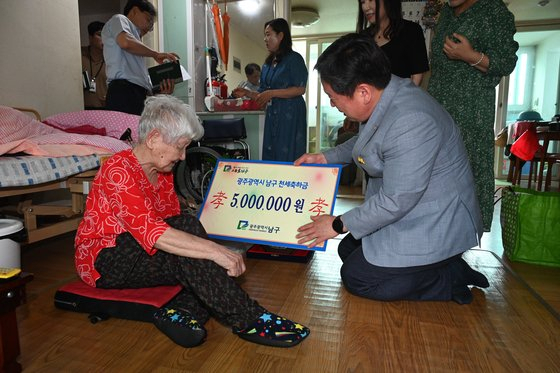 지난 3일 김병내 광주 남구청장이 올해 주민등록상 111세를 맞은 1911년생 어르신에게 천세 축하금을 전달하고 있다.[남구청 제공]