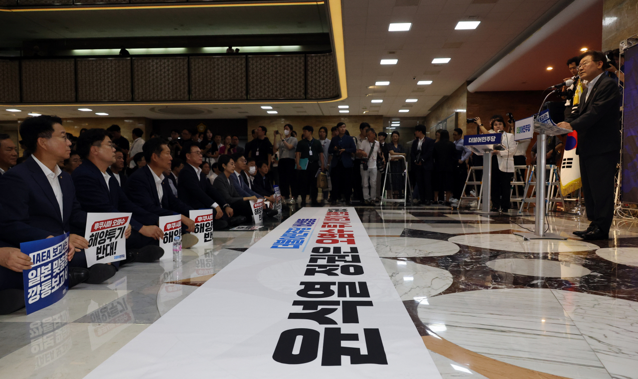 더불어민주당 의원들이 6일 국회 본회의장 앞에서 이재명 대표의 후쿠시마 원전 오염수 방류 반대 철야 농성 지지 발언을 듣고 있다. [연합]