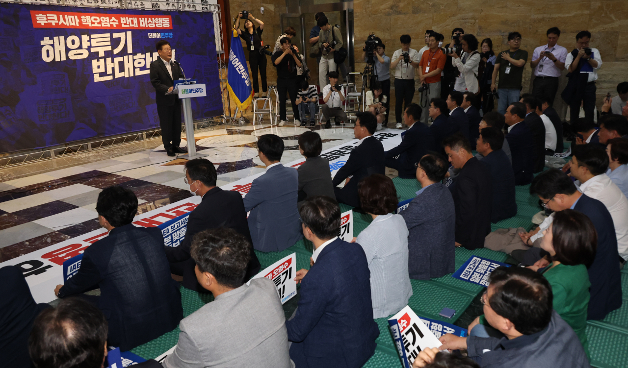민주당 의원들이 6일 국회 본회의장 앞에서 이재명 대표의 후쿠시마 원전 오염수 방류 반대 철야 농성 지지 발언을 듣고 있다. [연합]