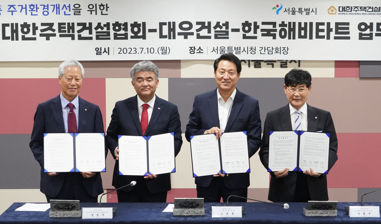 Hong Geung-sun, chairman of KHA’s Seoul branch, Jung Won-ju, chairman of Daewoo E&C and KHA, Seoul Mayor Oh Se-hoon and Yoon Hyung-ju, chairman of Habitat for Humanity Korea pose for a picture at the City Hall in central Seoul on Monday after signing an agreement to help repair houses in vulnerable areas. (Seoul Metropolitan Government)