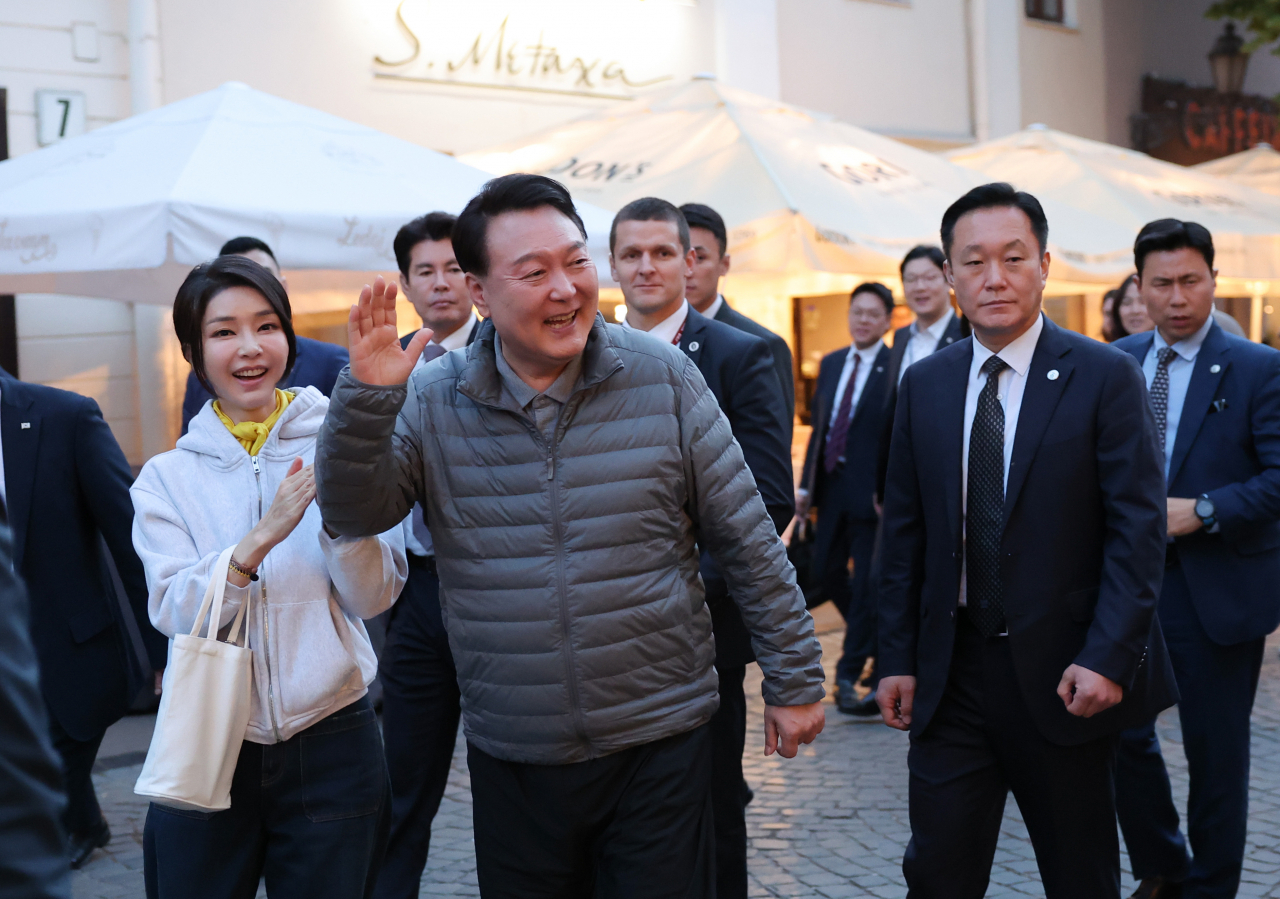 북대서양조약기구(NATO·나토) 정상회의 참석차 리투아니아를 방문 중인 윤석열 대통령과 김건희 여사가 10일(현지시간) 빌뉴스 구시가지를 산책하던 중 식당 야외 자리에서 식사 중인 피트 리케츠 미국 상원의원과 인사하고 있다. 빌뉴스 구시가지는 유네스코에 의해 세계문화유산으로 등재된 곳이다. [연합]