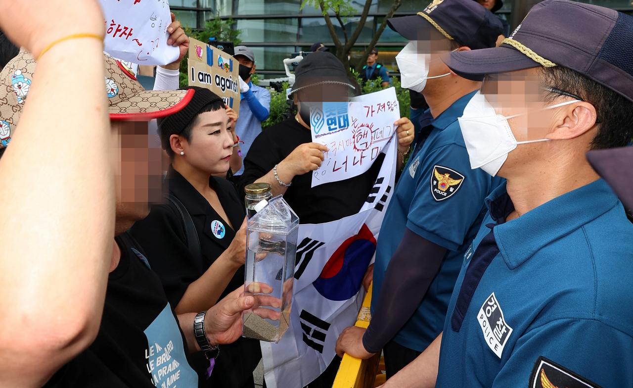 촛불연대 회원들이 지난 8일 서울 종로구 일본대사관 앞에서 직접 후쿠시마 원전 인근 해상에서 떠온 바닷물을 일본대사관 측에 전달하려다 경찰에 가로막히자 구호를 외치고 있다. [연합]
