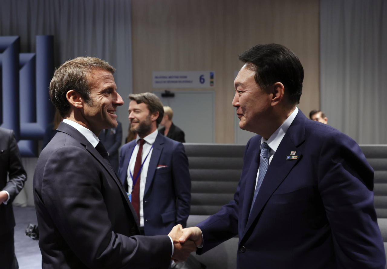 북대서양조약기구(NATO·나토) 정상회의 참석차 리투아니아를 방문 중인 윤석열 대통령이 11일(현지시간) 빌뉴스 나토 정상회의장에서 열린 한-스웨덴 정상회담을 마치고 나오던 중 에마뉘엘 마크롱 프랑스 대통령과 만나 악수하고 있다. [연합]