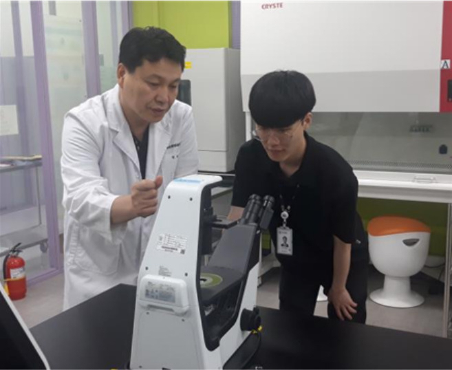 폴리텍대학 바이오캠퍼스 하철규 교수(왼쪽)와 논산시 농업기술센터 신지헌 주무관이 대학의 클린벤치(clean bench·무균시험대)와 고정밀 현미경을 사용해 배양실험을 하고 있다. [한국폴리텍대학 제공]