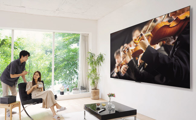 LG전자 모델이 세계 최초 무선 올레드 TV인 ‘LG 시그니처 올레드 M(LG SIGNATURE OLED M)’을 보고 있다. [LG전자 제공]