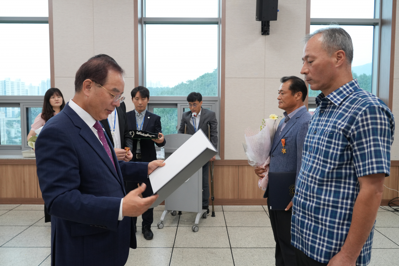 하윤수 부산시교육감(왼쪽)이 13일 오전 부산시교육청에서 열린 2023년 상반기 정부포상 전수식에서 퇴직·모범공무원에게 포상을 전수하고 있다. [사진=부산교육청]