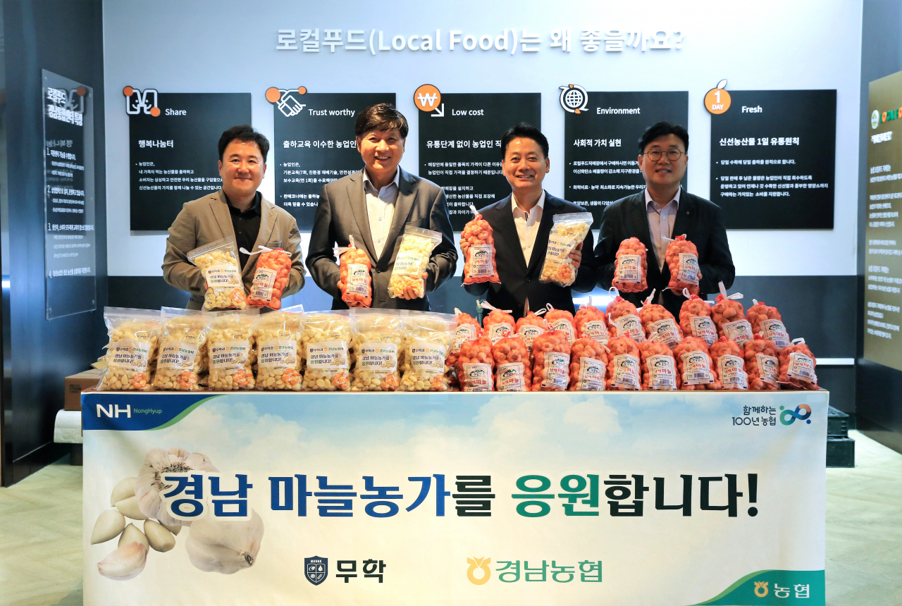 최재호 무학 회장(왼쪽 두 번째)과 김주양 경남농협 본부장(오른쪽 두 번째), 관계자들이 13일 농협 경남영업본부에서 경남 마늘 소비 촉진을 위한 공동마케팅을 진행하기로 하고 기념촬영을 하고 있다. [사진=무학]