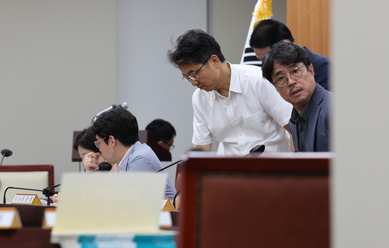 박준식 최저임금위원회 위원장을 비롯한 공익위원들이 13일 오후 세종시 정부세종청사 최저임금위원회 회의실에서 열린 제13차 전원회의가 긴 시간 정회 뒤 속개를 시작하자 자리에 착석하고 있다. [연합]