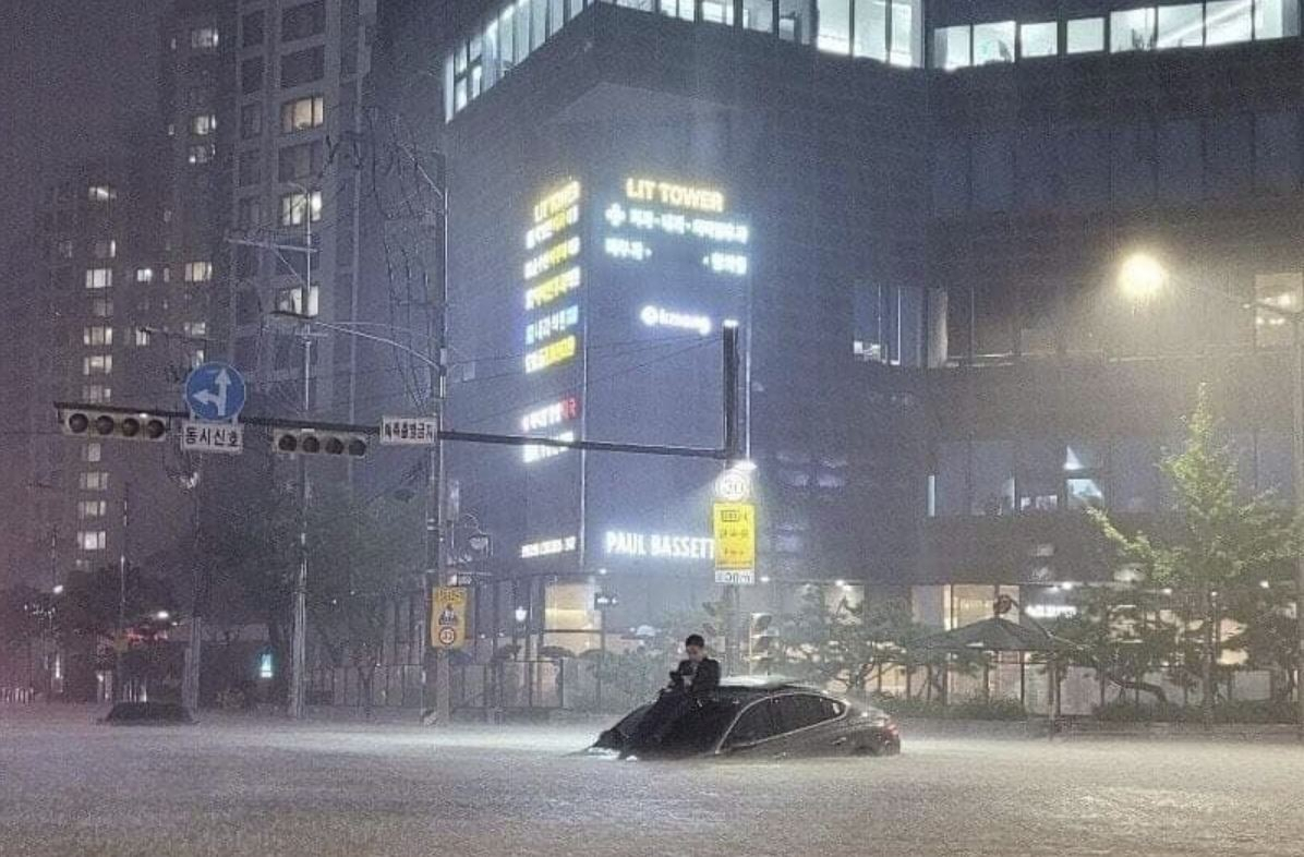 An individual nicknamed the "Wiseman of Seocho" sits on top of a vehicle, waiting to be rescued in Seoul's Gangnam district on Aug. 8, 2022. (Online community)