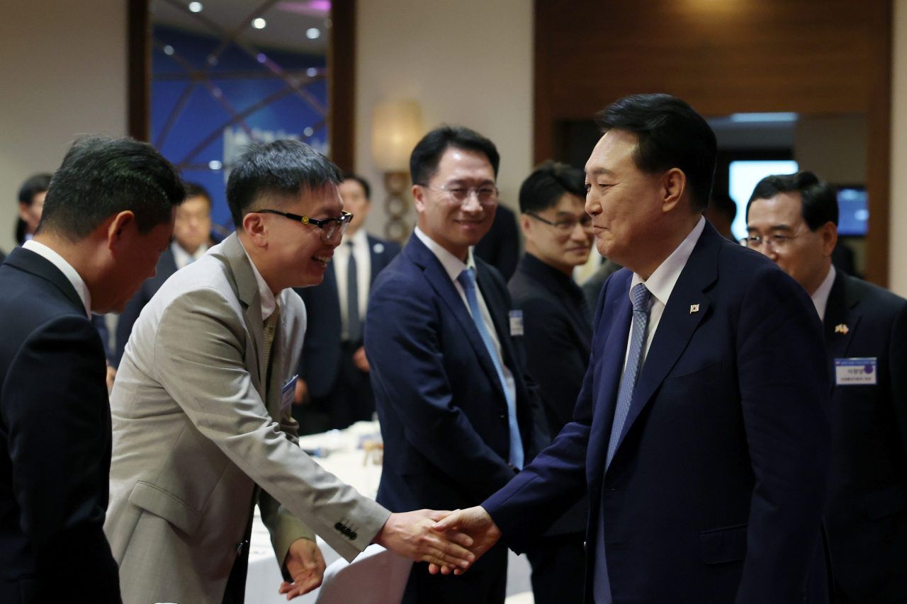 폴란드를 공식 방문 중인 윤석열 대통령이 14일(현지시간) 바르샤바 시내 한 호텔에서 열린 폴란드 진출 기업인 오찬 간담회에서 참석자들과 인사를 나누고 있다. [연합]