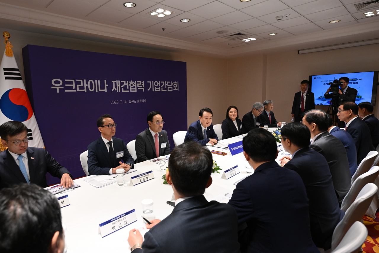 폴란드를 공식 방문 중인 윤석열 대통령이 14일(현지시간) 바르샤바 한 호텔에서 열린 우크라이나 재건 협력 기업 간담회에서 참석자들과 대화하고 있다. [연합]