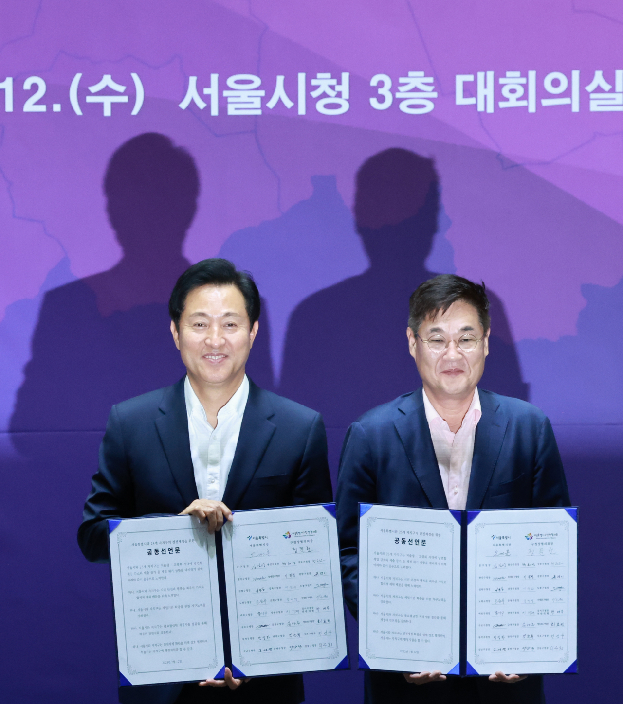 오세훈 서울시장과 서울시구청장협의회장인 정문헌 종로구청장이 12일 서울 중구 시청 대회의실에서 열린 ‘서울시-구청장협의회 건전재정 공동선언’ 행사에서 서명을 마친 공동선언문을 들어보이고 있다. [연합]