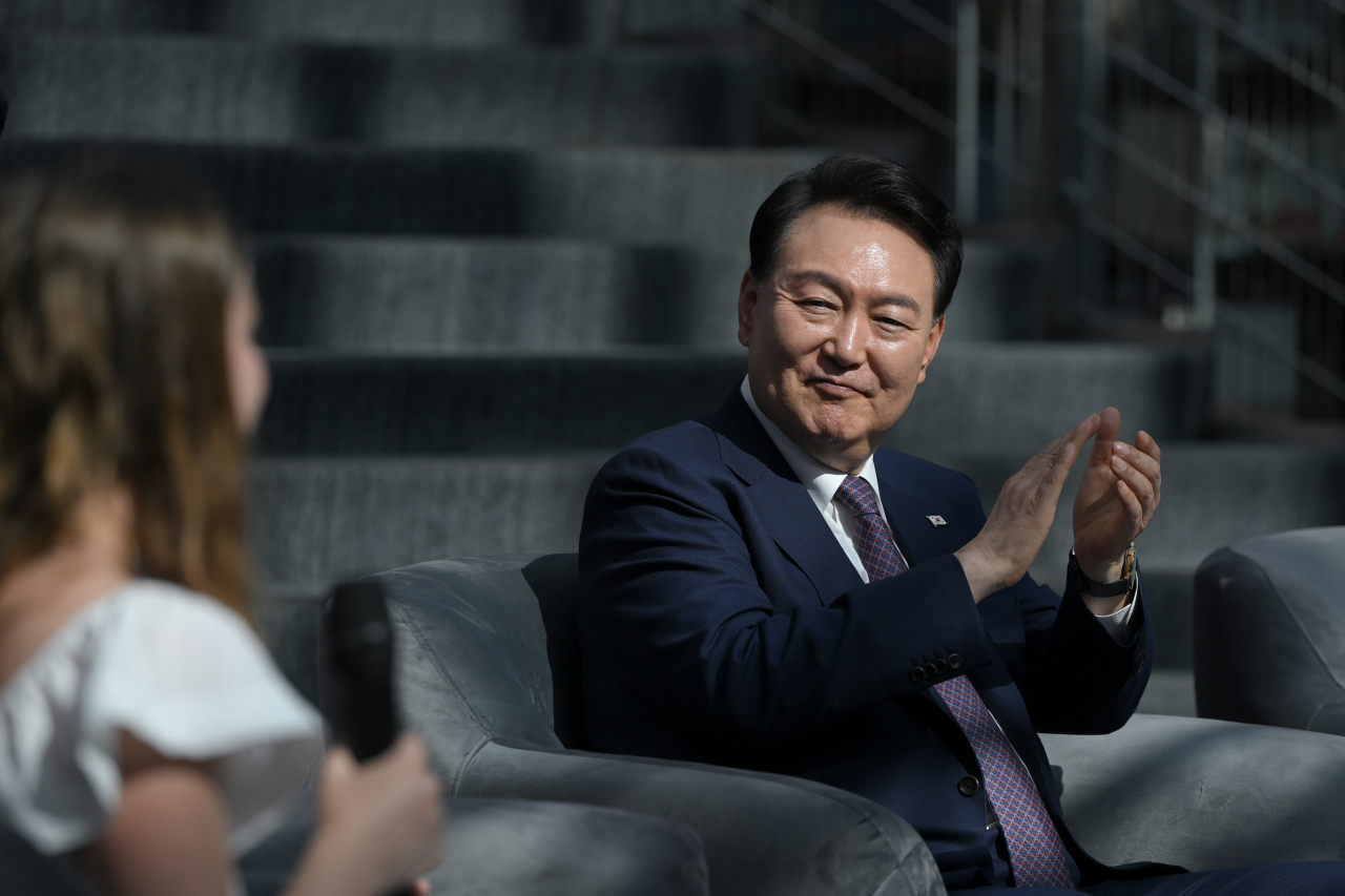 폴란드를 공식 방문 중인 윤석열 대통령이 14일(현지시간) 바르샤바대학교 중앙도서관에서 열린 폴란드 미래세대와의 문화동행에서 참석자의 소감 발표에 박수치고 있다. [연합]