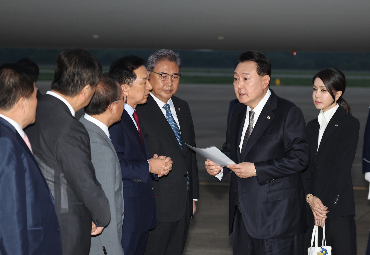 리투아니아에서 열린 북대서양조약기구(NATO·나토) 정상회의와 폴란드·우크라이나 방문을 마친 윤석열 대통령이 17일 성남 서울공항을 통해 귀국해 국민의힘 김기현 대표가 준비한 자료를 보며 박진 외교부 장관 등과 대화하고 있다. [연합]